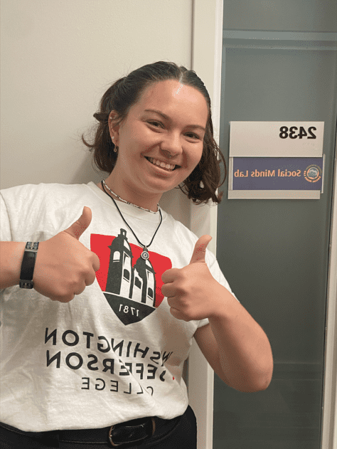 W&即将升入高年级的茱莉亚·赫维茨站在密歇根大学社会心理实验室外竖起了两个大拇指.